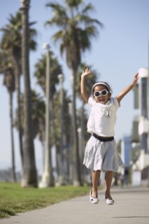 Young mixed race girl wearing sunglasses and jumping