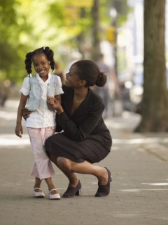 African businesswoman hugging girl