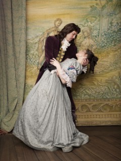 Actors in old-fashioned costumes hugging on stage
