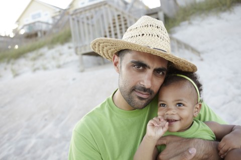 Father holding daughter on beach