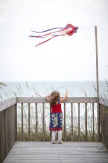 Girl standing on deck near ocean