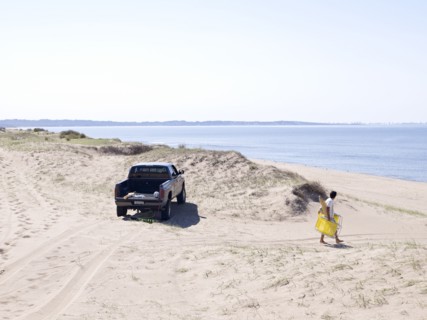 Hispanic man carrying lounge chair to beach