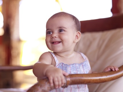 Hispanic baby girl sitting in chair
