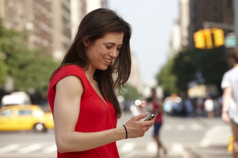 Caucasian woman using cell phone in city street