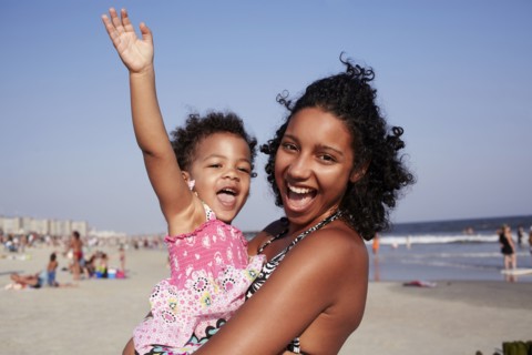 Mixed race mother and daughter enjoying the beach