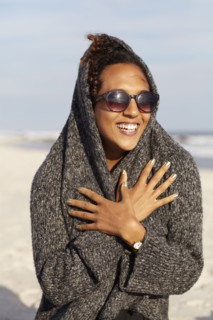 Mixed race woman in sweater on beach