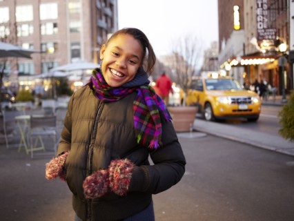 Mixed race girl smiling on city street