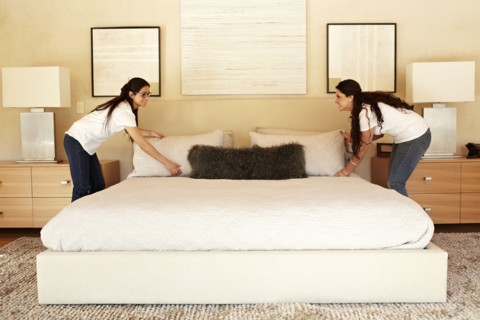 Hispanic women making bed