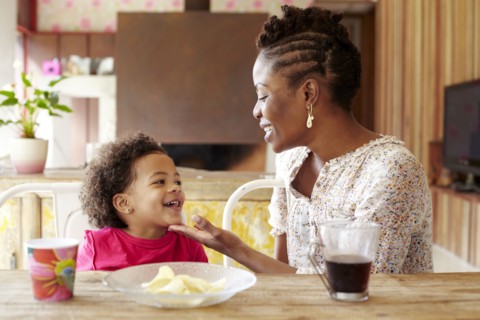 Mother and daughter talking at breakfast table