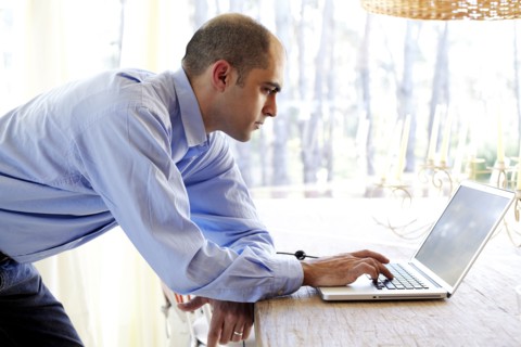 Mixed race businessman using laptop in office