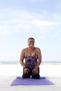 Woman practicing yoga on beach