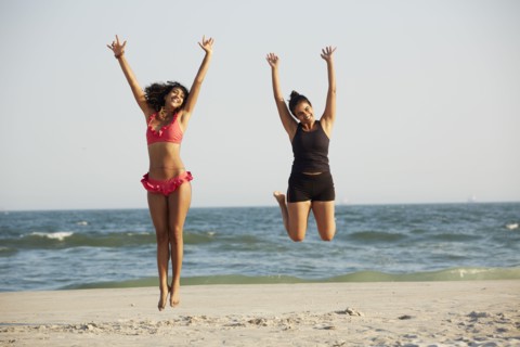 Women jumping for joy on beach