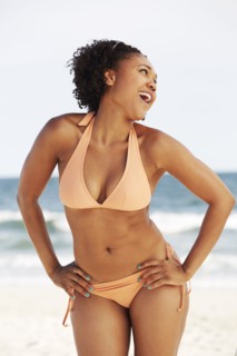 Mixed race woman smiling on beach