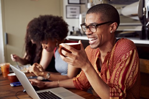 People using technology in coffee shop