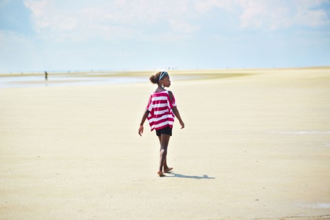 Black girl walking on beach