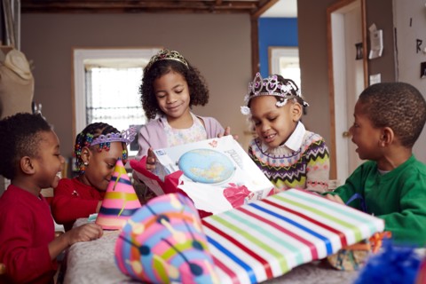 Children wearing tiaras and opening gifts