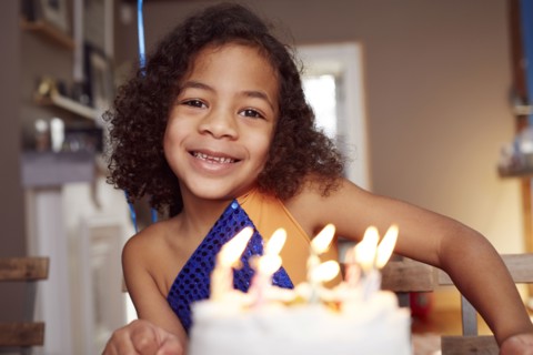 Mixed race girl with cake and candles