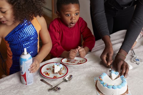 Excited children anticipating cake at party