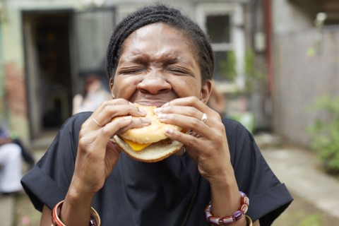 African American woman eating at backyard barbecue