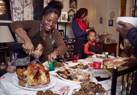 Mother and daughter carving turkey at holiday dinner