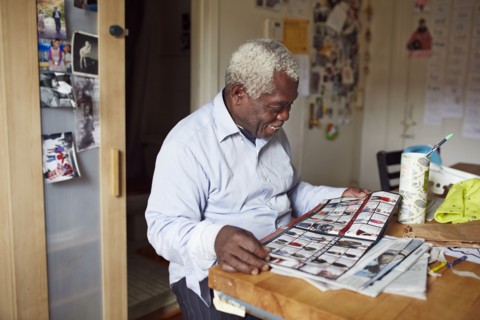 Black man reading magazine at table