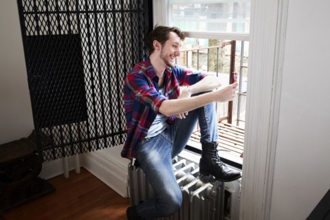 Caucasian man using cell phone in window