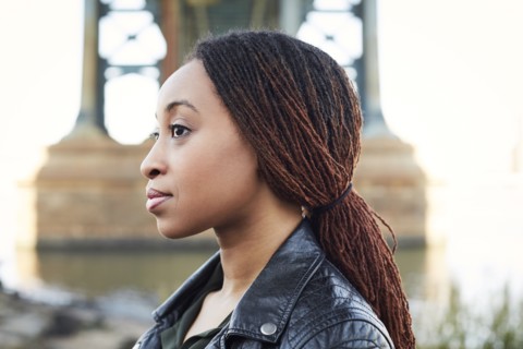 Profile of serious Black woman at bridge