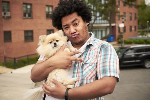 Mixed Race man gesturing peace with dog in city