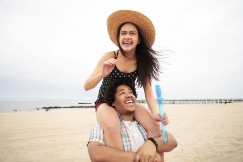 Man carrying woman on shoulders at beach