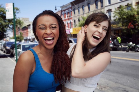Friends laughing on city sidewalk