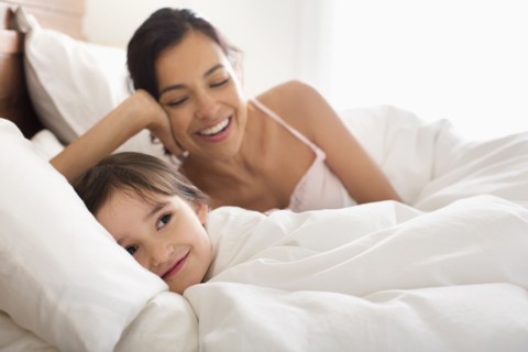 Mother and daughter laying in bed