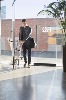 Korean businessman wheeling bicycle in office