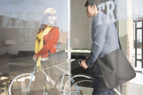 Business people wheeling bicycles in office