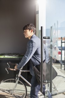 Korean businessman wheeling bicycle in office