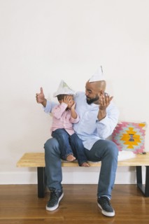African American father and son playing on bench