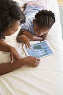 African American mother and daughter using digital tablet