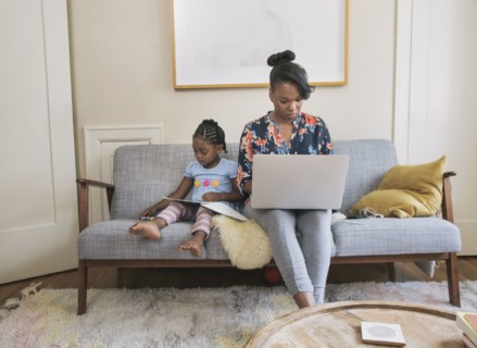 African American mother and daughter relaxing in living room