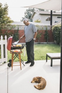 African American man grilling in backyard