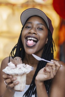 Mixed Race woman showing heart-shape candy on tongue