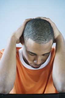 Young man holding his head in his hands