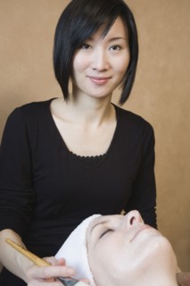 Asian woman performing spa treatment