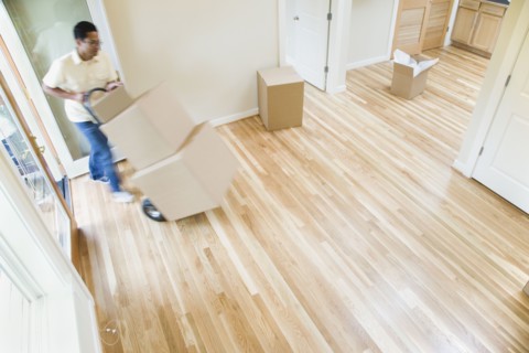 Asian man moving boxes in new house