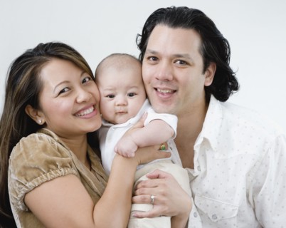 Asian parents hugging baby