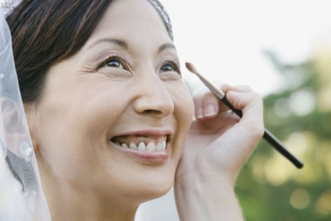 Asian bride having makeup applied