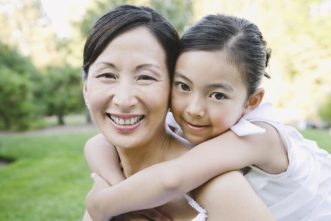 Asian bride and flower girl hugging