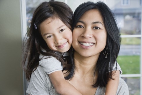 Mixed Race mother and daughter hugging