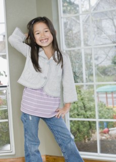 Mixed Race girl posing next to window