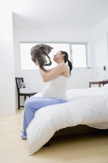 Pregnant Asian woman holding cat