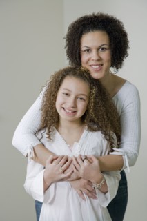 Mixed race mother and daughter hugging