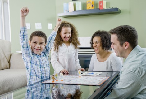 Mixed race family playing board game